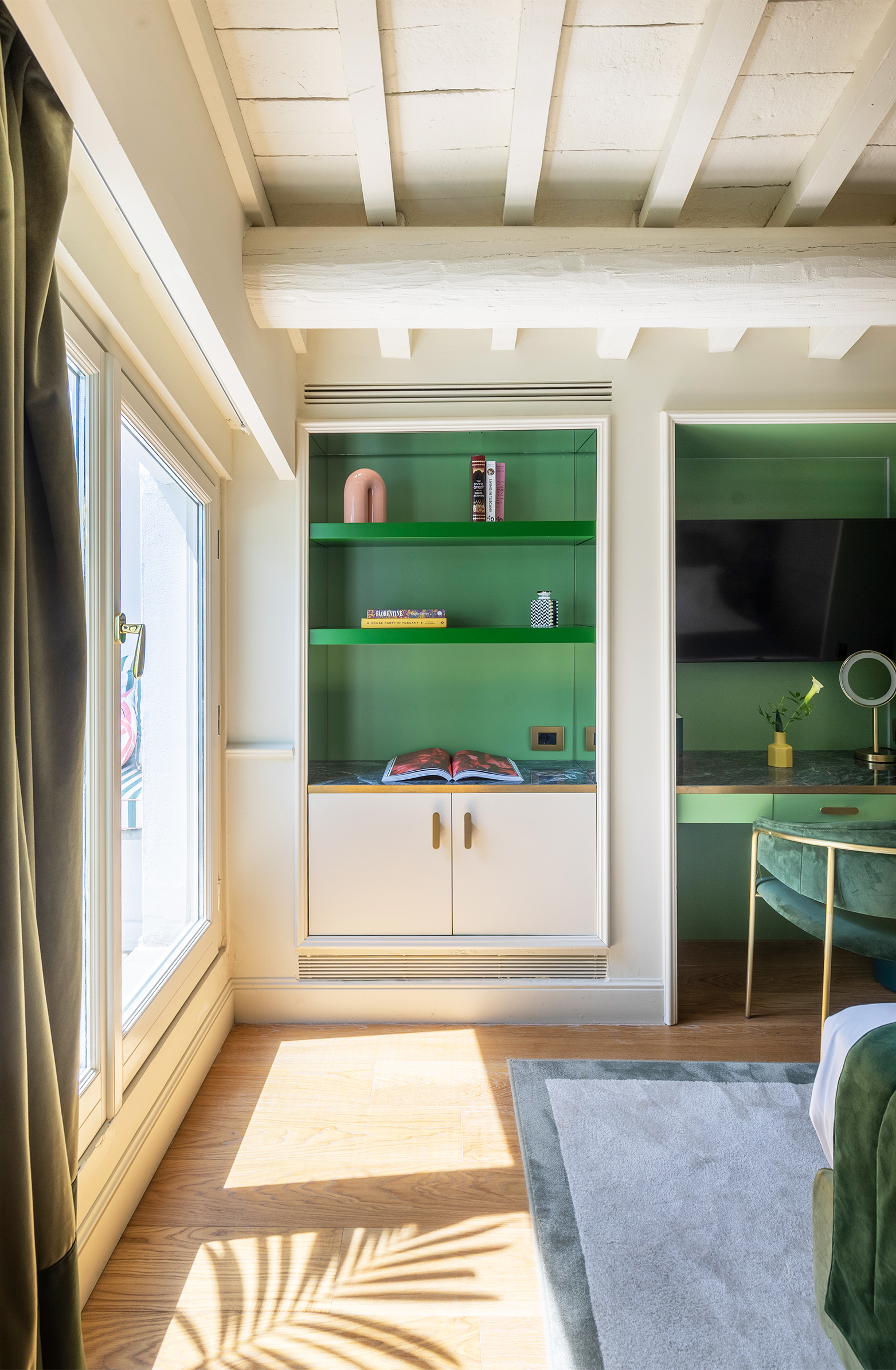 Executive Suite with green built-in shelving, white cabinets and a sunlit window