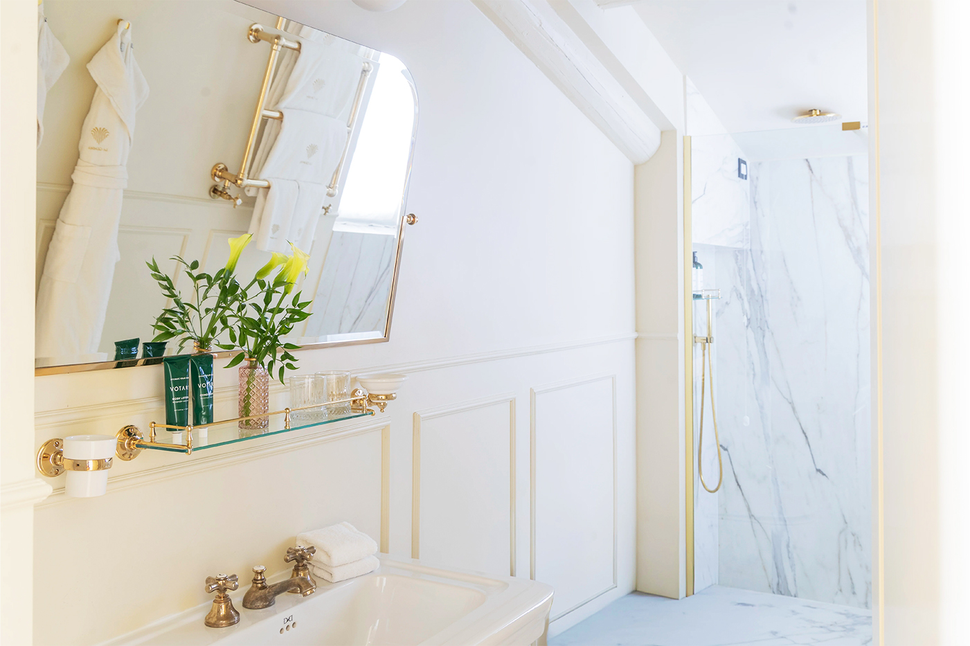 Loft Suite marble bathroom with sink and walk-in shower beneath the attic eaves