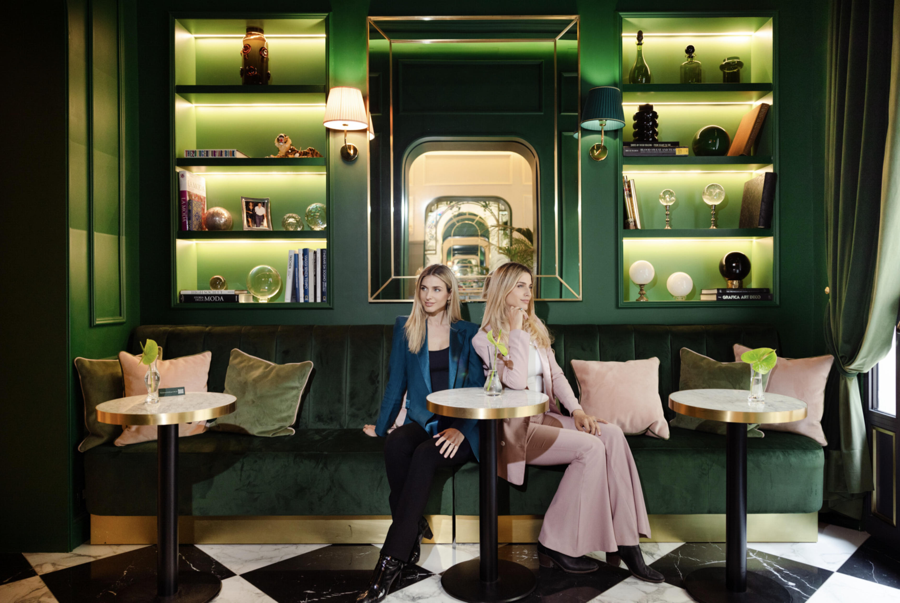 Two women seated in La Gemma's emerald-green bar lounge